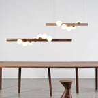 Walnut linear pendant light suspended above a kitchen island