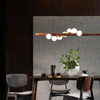Five opal glass globes lit along a horizontal walnut bar