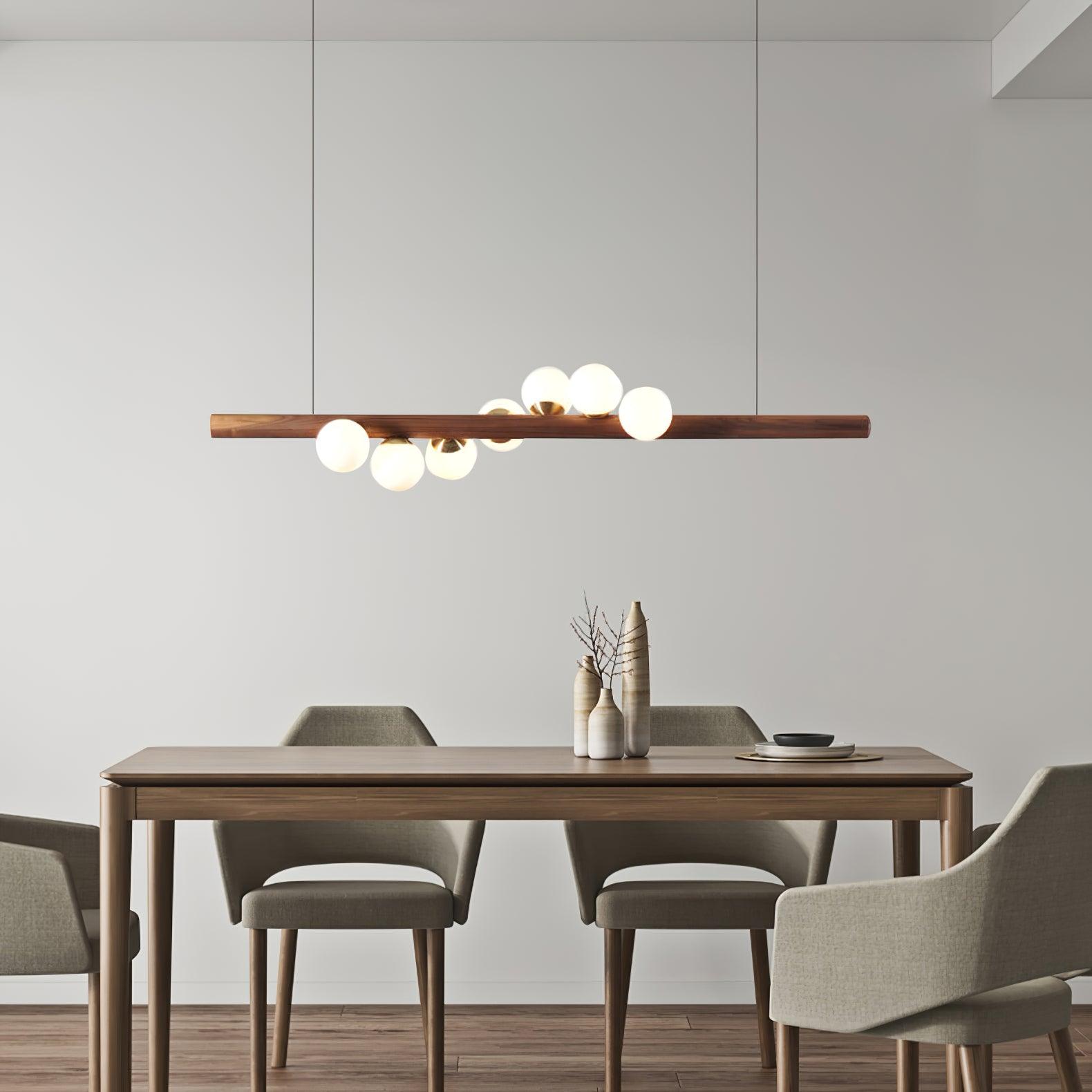 Linear walnut pendant casting a warm even glow over a table