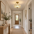 At the end of a hallway with a console table and olive branches, this Clérachic ceiling light glows near the front door.