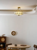 Close beneath the same crown moulding, this Clérachic ceiling light glows warm above a dining nook.