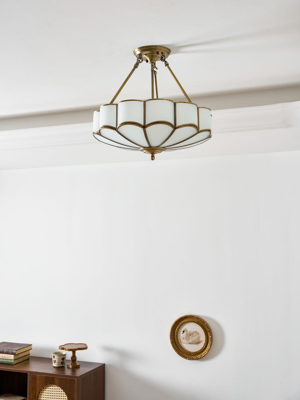 In a plain room with a small wall clock and a wooden cabinet, this Clérachic ceiling light glows close to the ceiling.