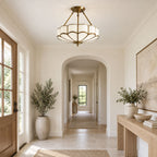 In an entryway with a glazed door and a potted olive tree, this Clérachic ceiling light glows above the tiled floor.