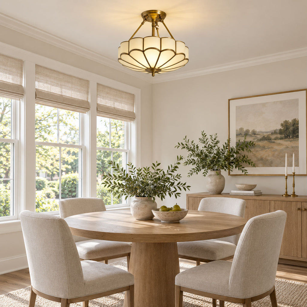 Above a round wood dining table with woven roman shades nearby, this Clérachic ceiling light glows warm in the room.
