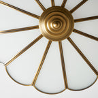 A bare brass spoke frame is shown beside this Clérachic ceiling light, its ribs radiating from a central mount with no glass fitted.