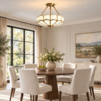 Above a round dining table by arched black-framed windows, this Clérachic ceiling light glows warm in a neutral dining room.