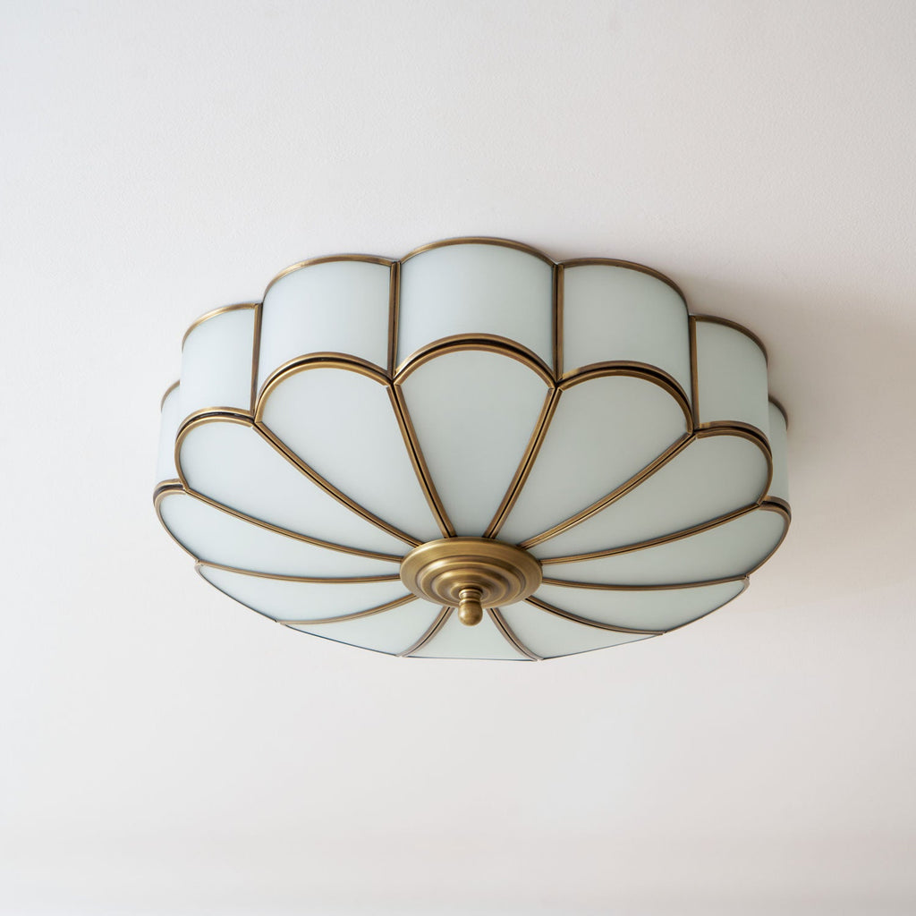 Flower-shaped ceiling light with brass frame in an interior