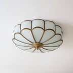 Flower-shaped ceiling light with brass frame in an interior