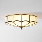 Brass-framed flower ceiling light glowing in a bedroom