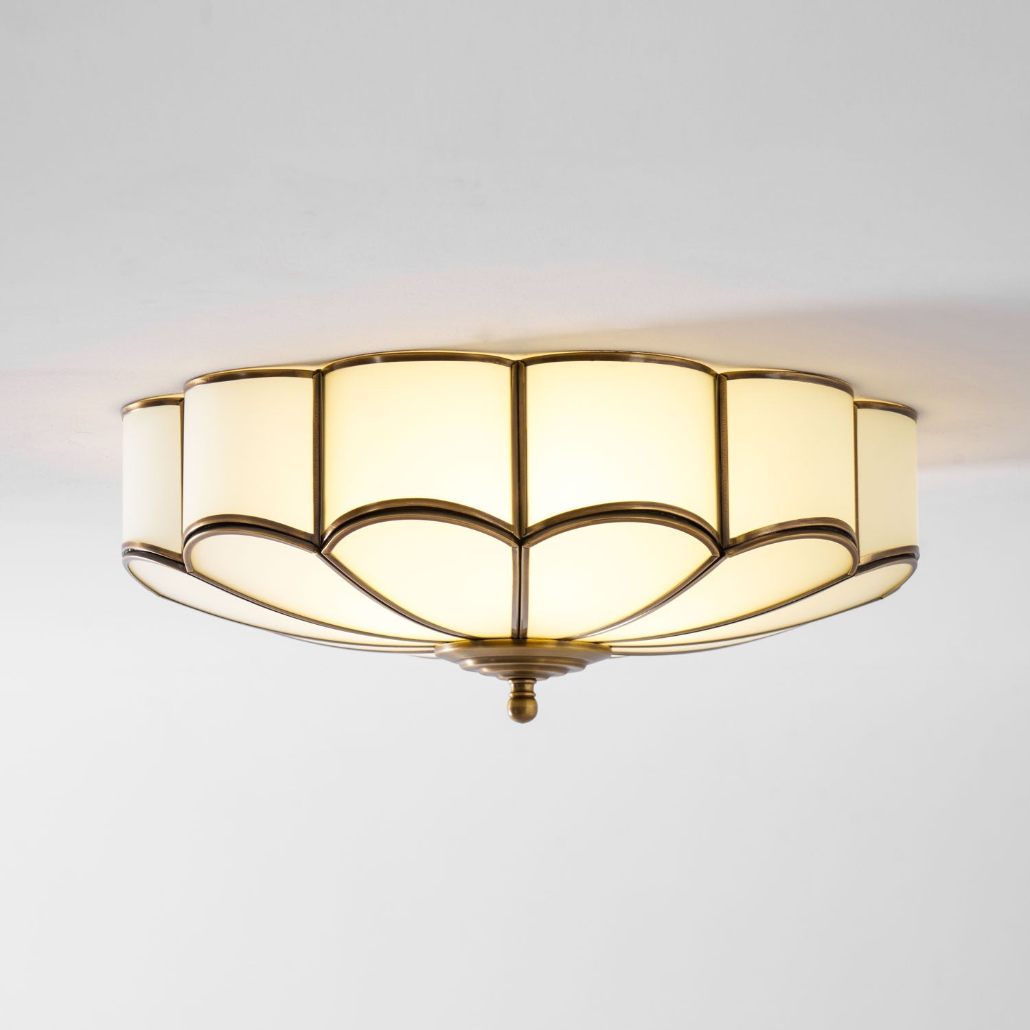 Brass-framed flower ceiling light glowing in a bedroom