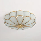 Frosted glass petal ceiling light with brass frame glowing softly