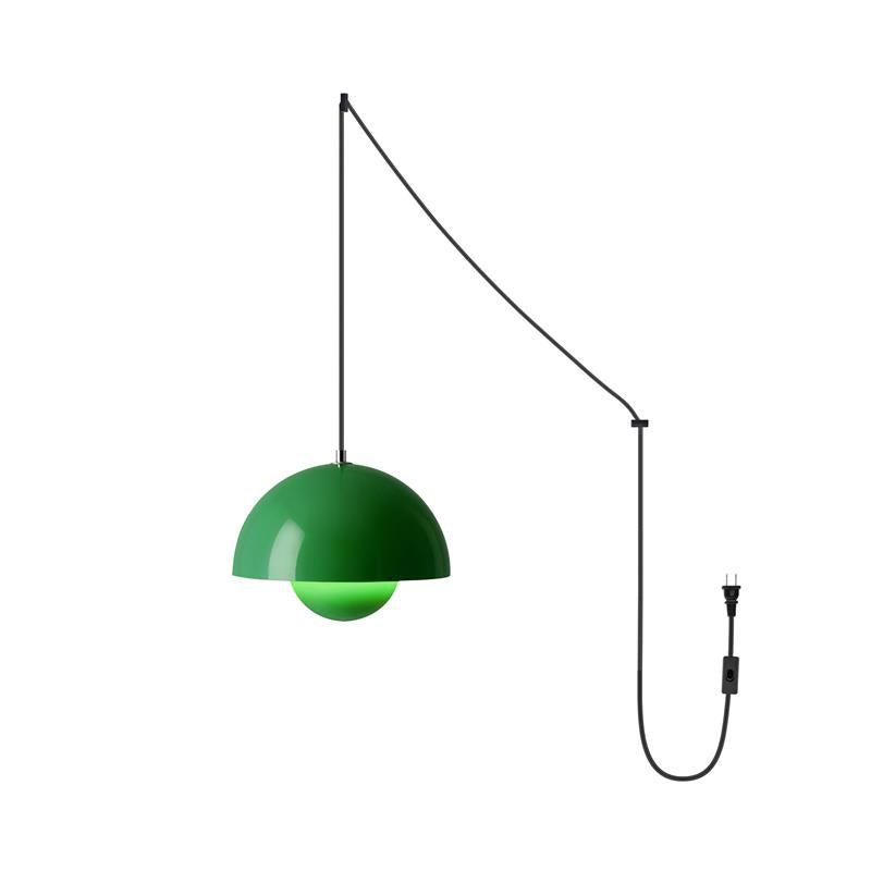 Vivid green shade switched on, black cord angled from ceiling hook to wall hook and down