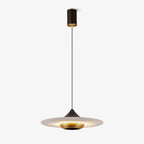 Clérachic flat disc pendant light hangs slightly off-centre on its cord, photographed against an off-white backdrop.