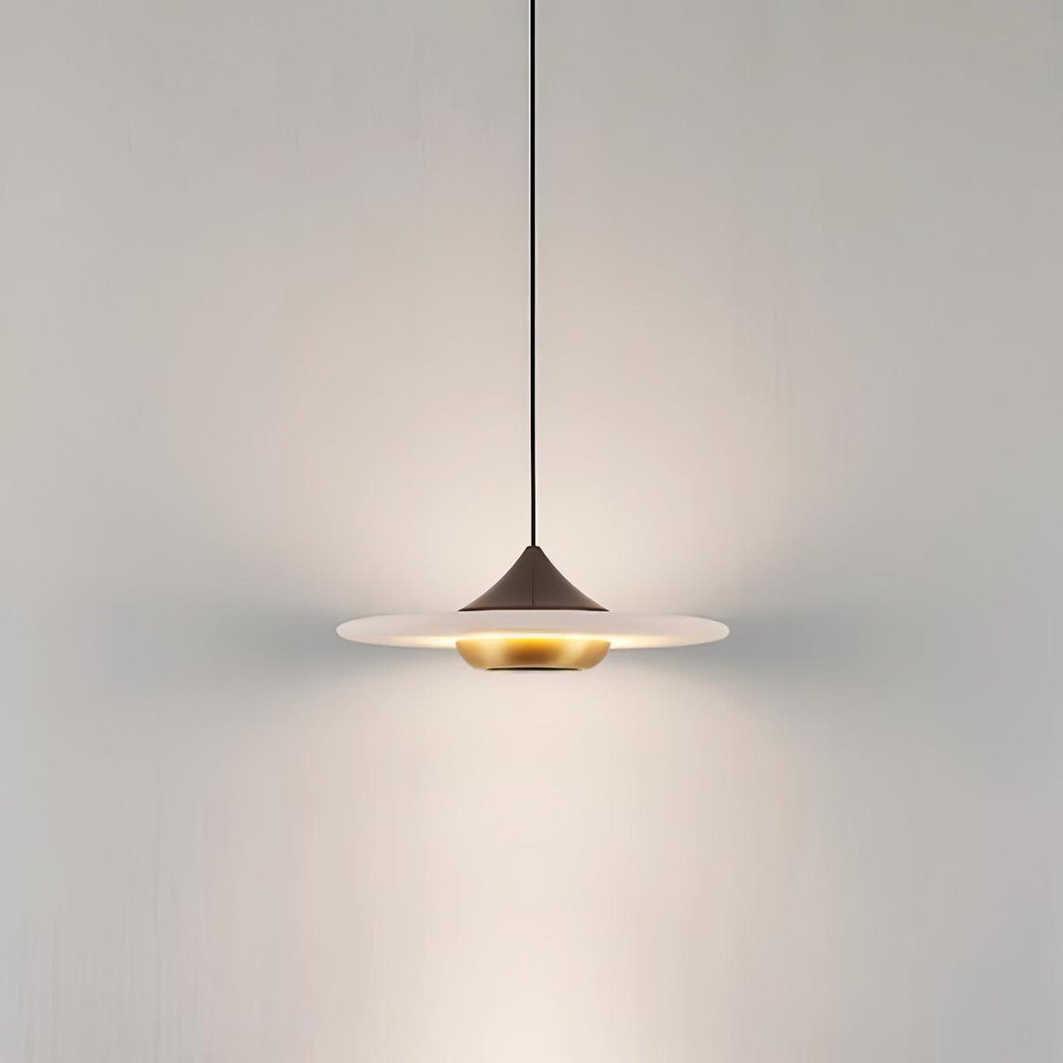Clérachic white marble disc pendant light on a black cord and dome fitting, photographed on a plain grey background.