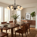 Over a wood dining table with woven-leather chairs, this Clérachic chandelier's black finish glows beneath a coffered ceiling.