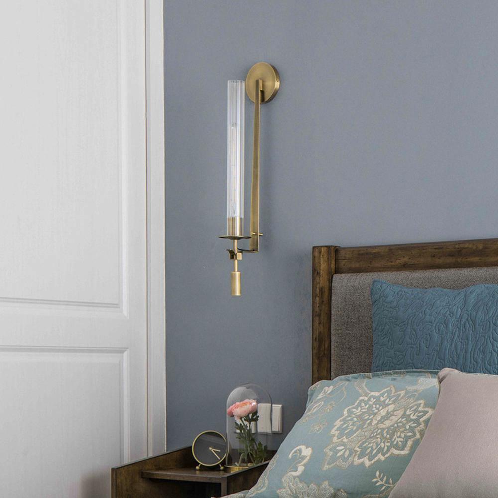 Brass sconces with ribbed glass shades lighting a wall