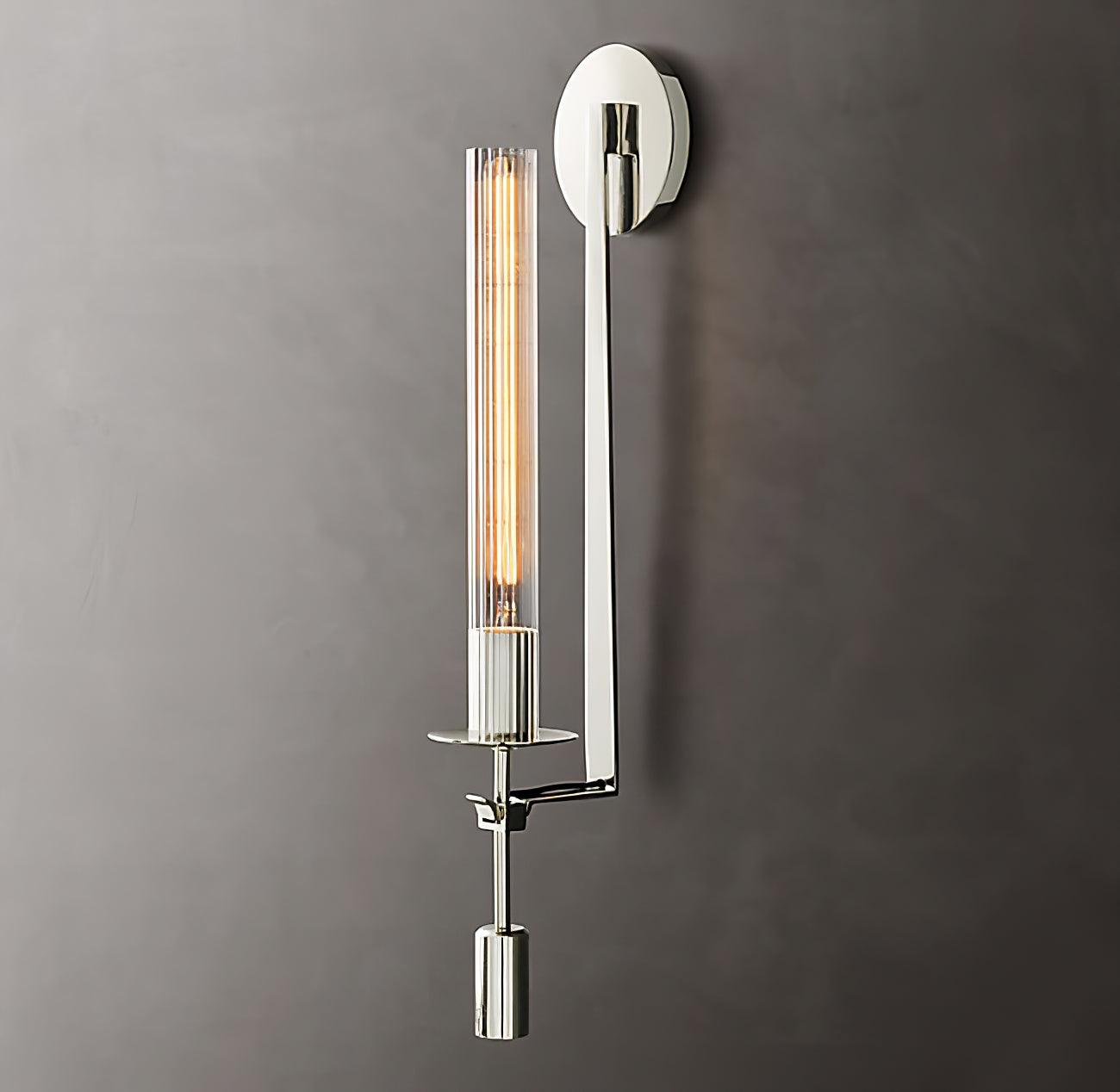 Brass wall sconce with cylindrical ribbed glass shade on wall