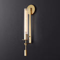 Brass wall sconce with ribbed glass cylinder shade lit warmly
