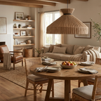 In an open living space, this Clérachic pendant hangs above a round dining table near a leather armchair and sofa.