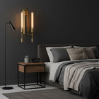 Brass wall sconce flanking a bed with warm candle-like glow