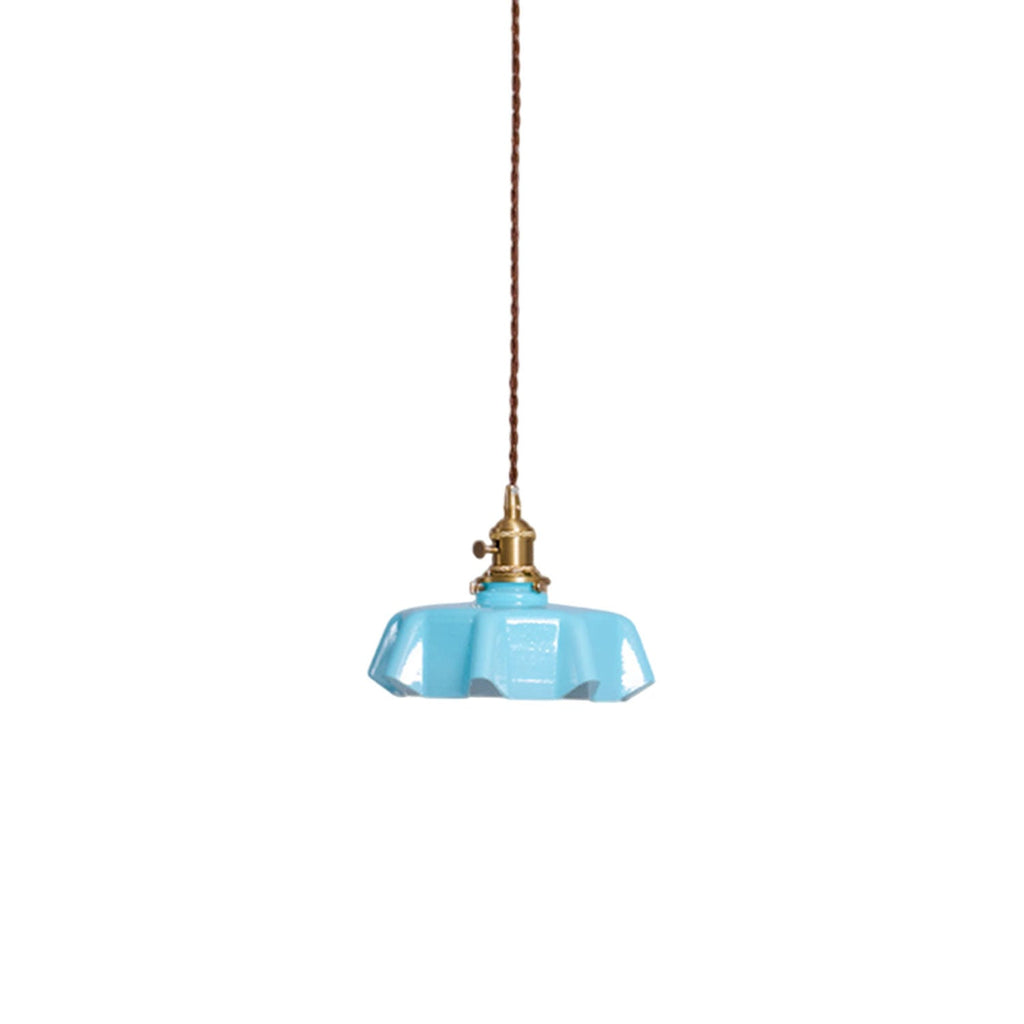Pleated glass pendant light with warm brass fitting lit softly