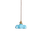 Pleated glass pendant light with warm brass fitting lit softly