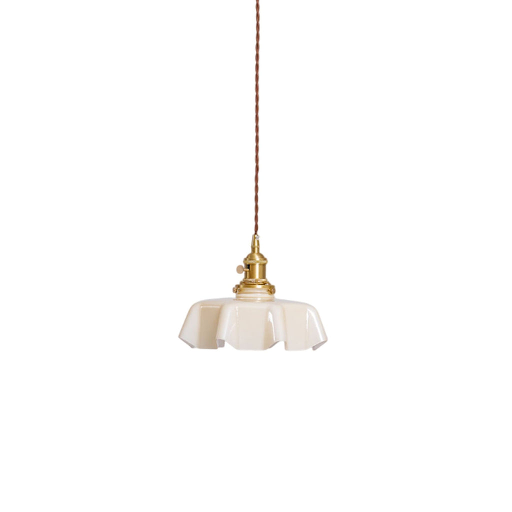 Pleated glass pendant light glowing warmly over a table