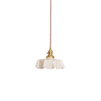 Pleated glass pendant light glowing warmly over a table