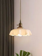 Pleated glass pendant light hanging in a warm interior setting