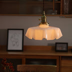 Pleated glass pendant light glowing above a kitchen worktop