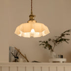 Pleated glass pendant light hanging in a styled interior