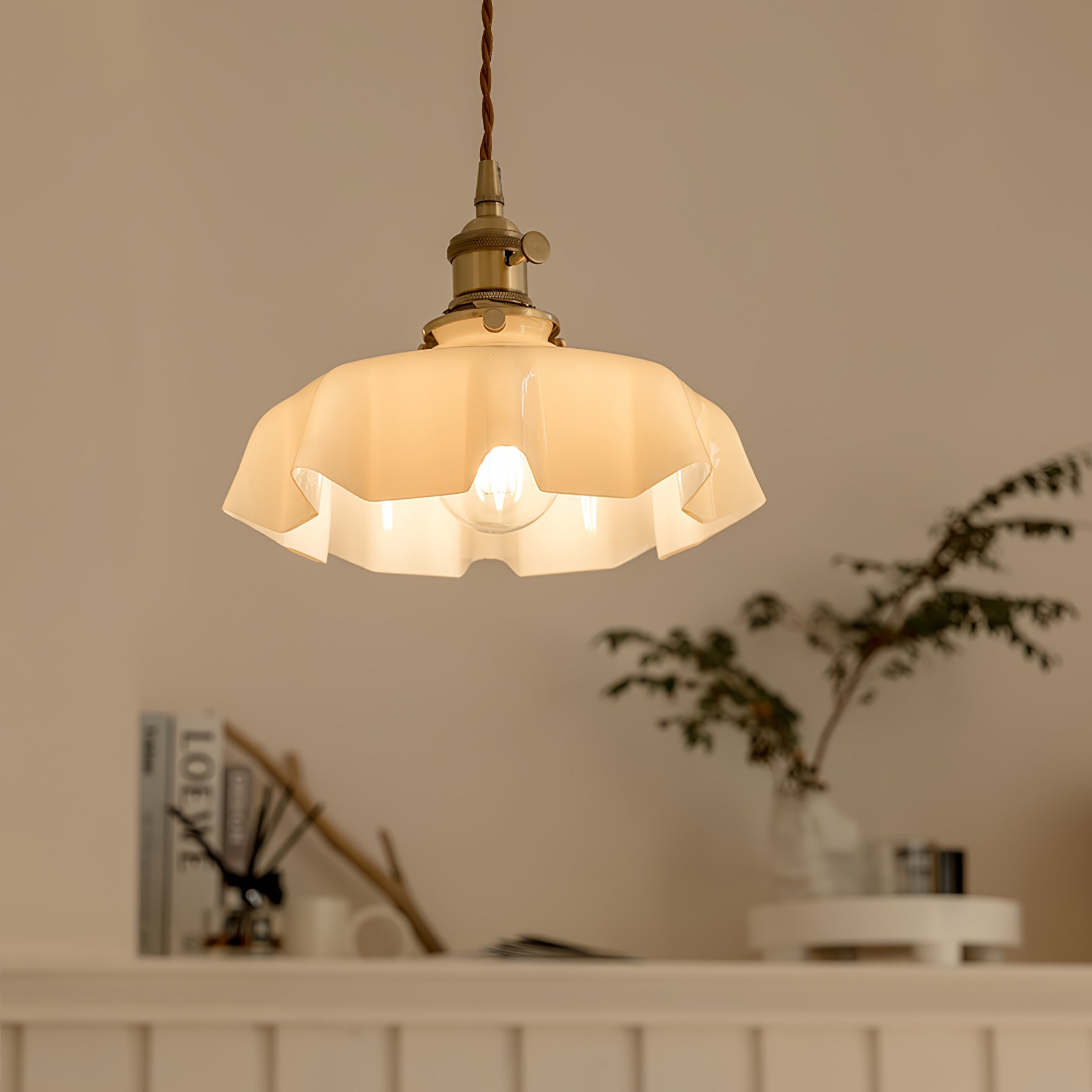 Pleated glass pendant light hanging in a styled interior