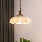 Pleated glass pendant light hanging over a styled table setting