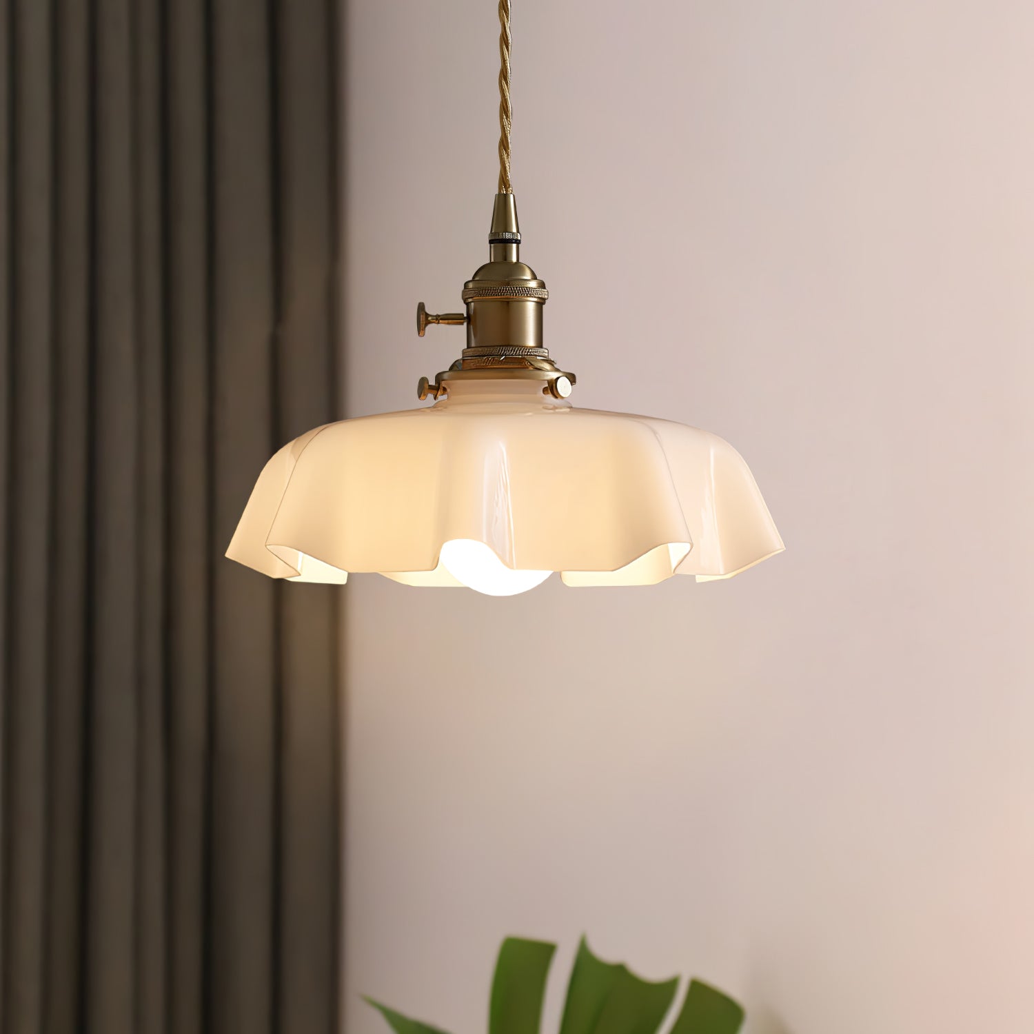 Pleated glass pendant light hanging over a styled table setting
