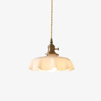 Lit against a plain grey backdrop, this Clérachic pendant's beige pleated glass shade hangs from its twisted brass-fitted cord.