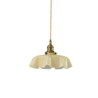A plain white studio shot shows this Clérachic pendant's pale beige pleated glass shade on its twisted brass-fitted cord.