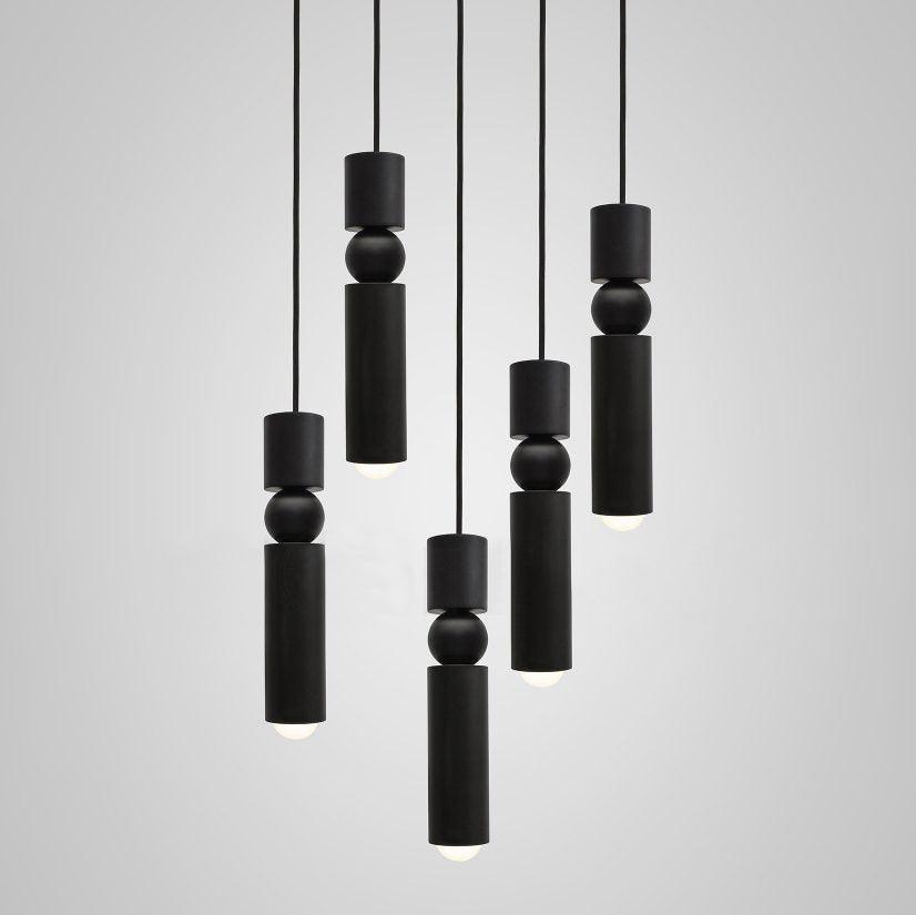 Geometric pendant light with cylinders over a stairwell
