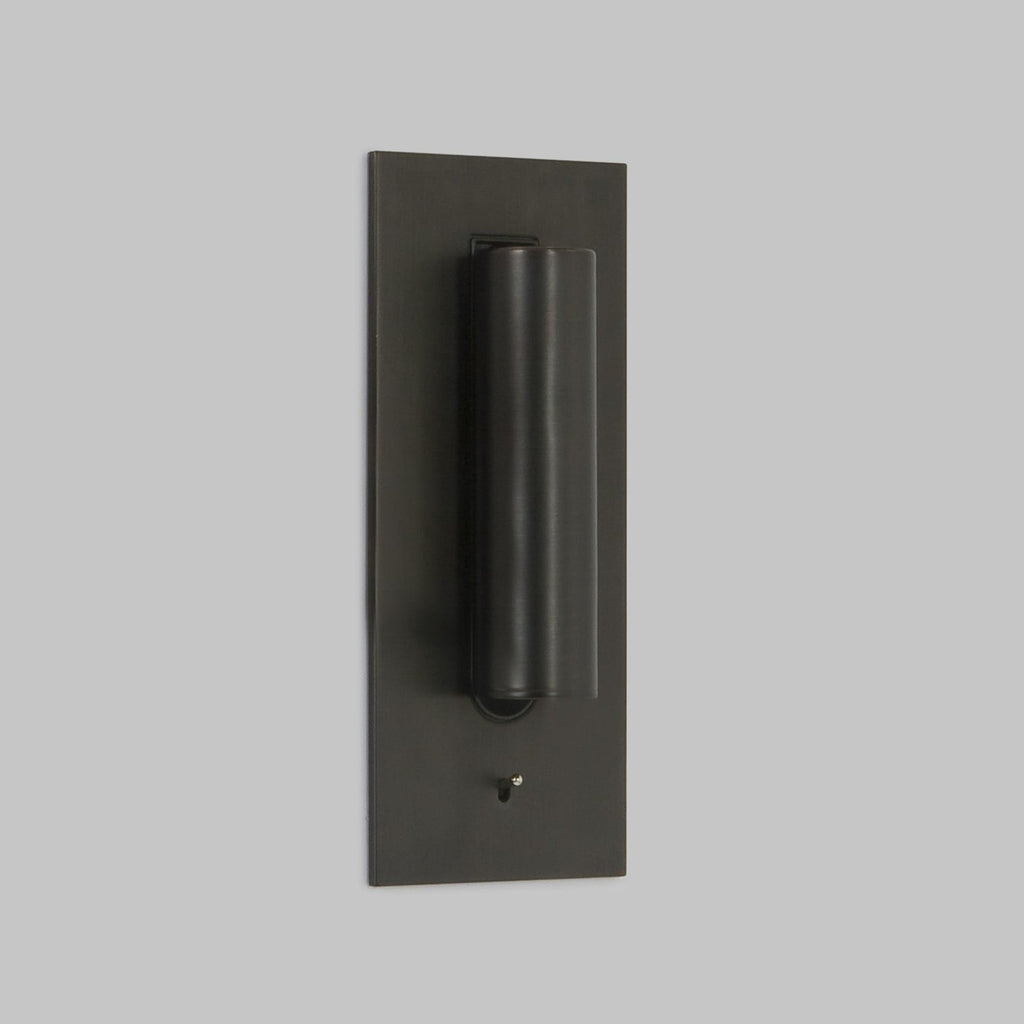 Front view of this Clérachic reading light in bronze, unlit, head down, on a plain grey background.