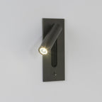 Mounted on a plain grey wall, this Clérachic reading light in bronze glows down at an angle.