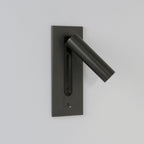 This Clérachic reading light in bronze, unlit, head swung out to the side, on a plain grey background.