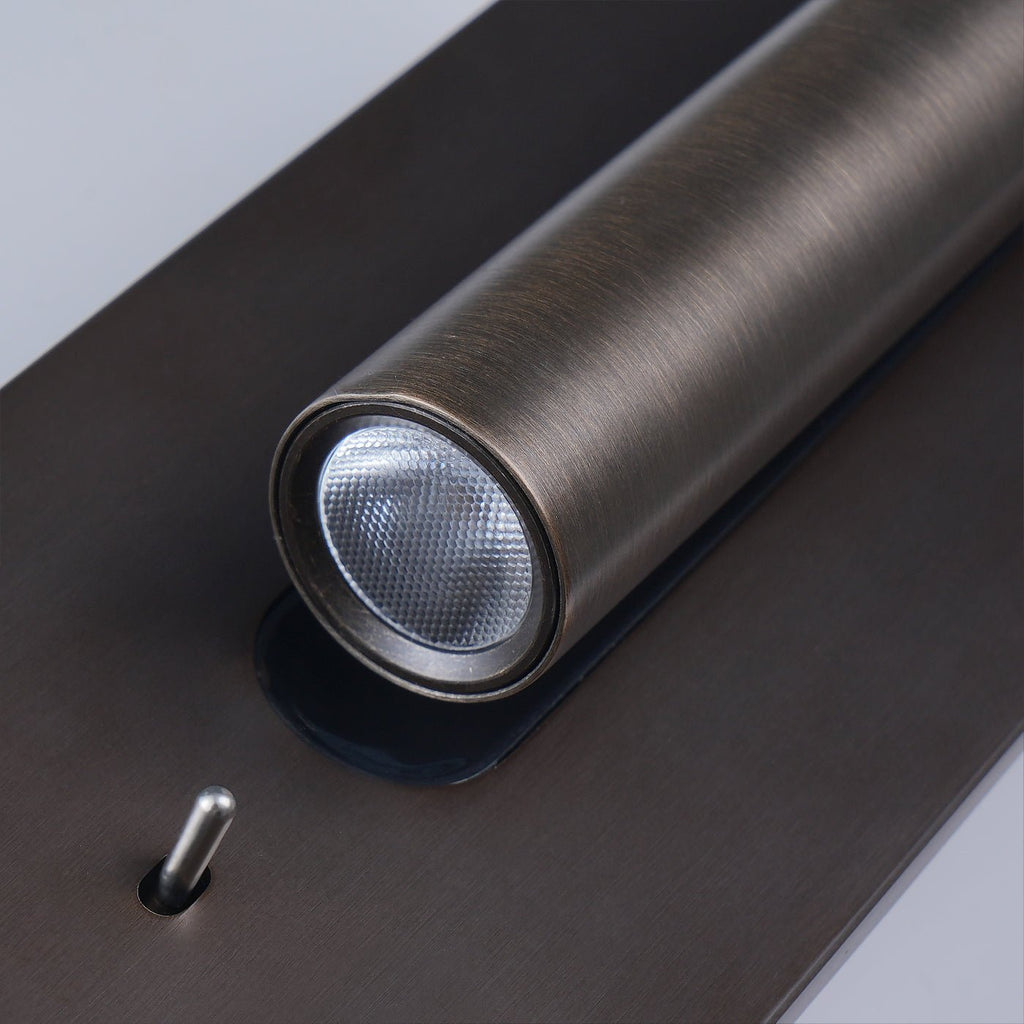 Close view of the lit LED lens on this Clérachic reading light in bronze, angled toward the camera.