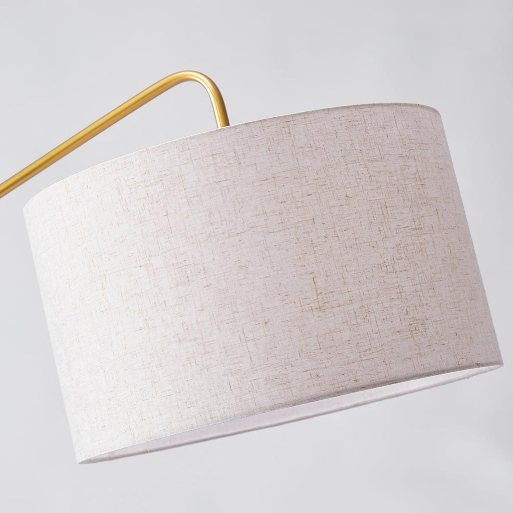 Clérachic black arc floor lamp in close-up, the textured linen drum shade filling the frame with its gold arm above.