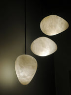 Three shades lit in a dark interior, the alabaster glowing warm and showing its grain