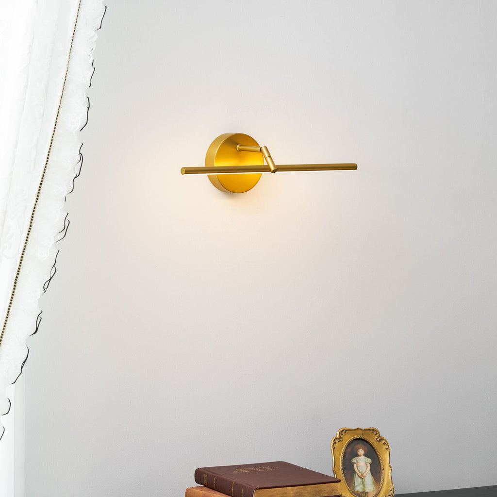 Side-angle close view of this gold-finish Clérachic wall light, lit, its canopy and bar set against a plain wall.