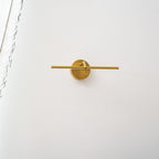 A gold-finish Clérachic wall light shown alone on a plain wall, unlit, angled slightly from the front with no furniture below.