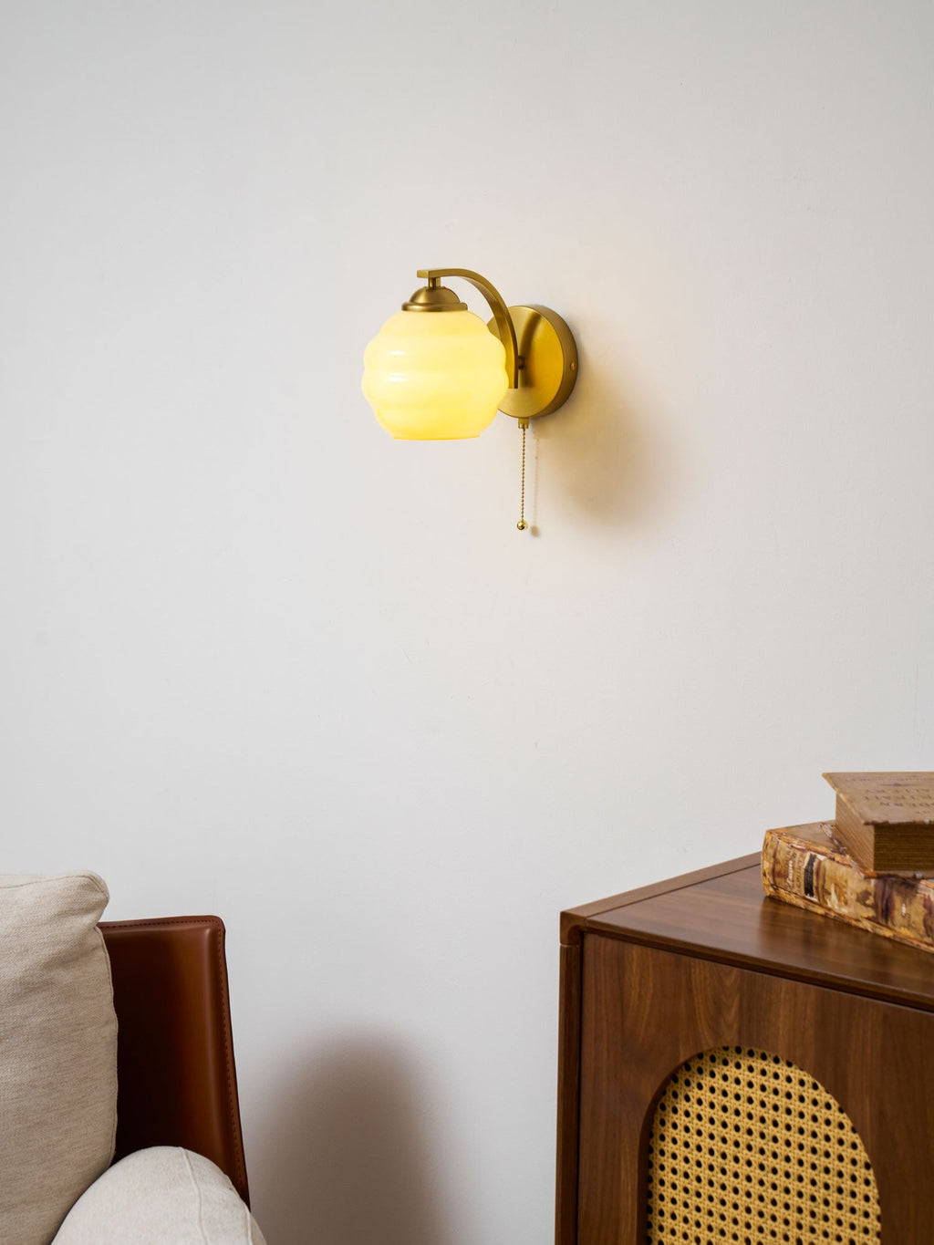 Gatsby wall lamp lit beside a dark painted accent wall