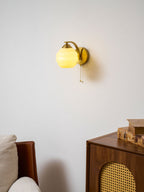Gatsby wall lamp lit beside a dark painted accent wall