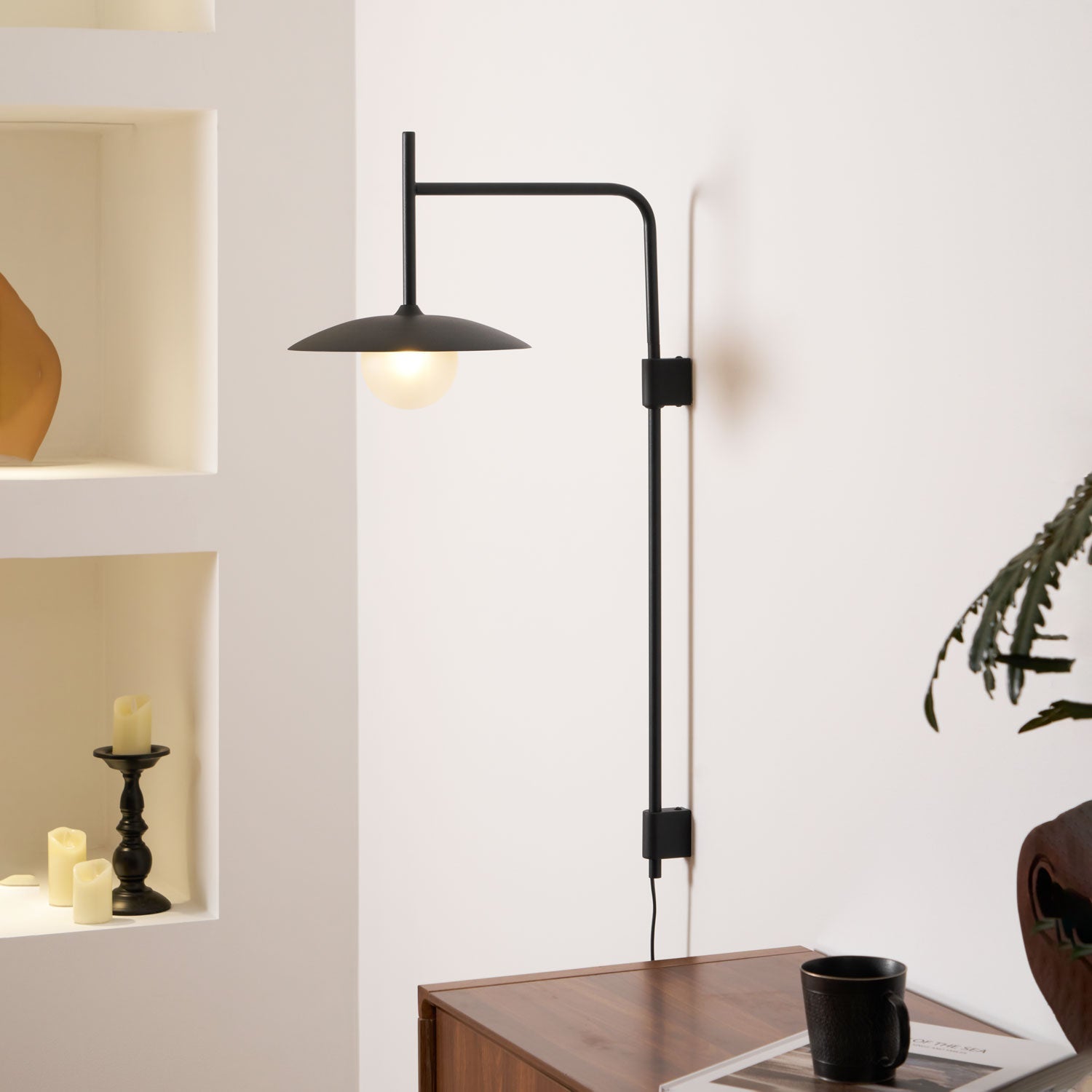 Plug-in swing arm wall lamp angled over a reading chair