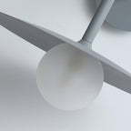 Close view of the glass globe bulb tucked beneath the disc shade of this grey Clérachic wall light.