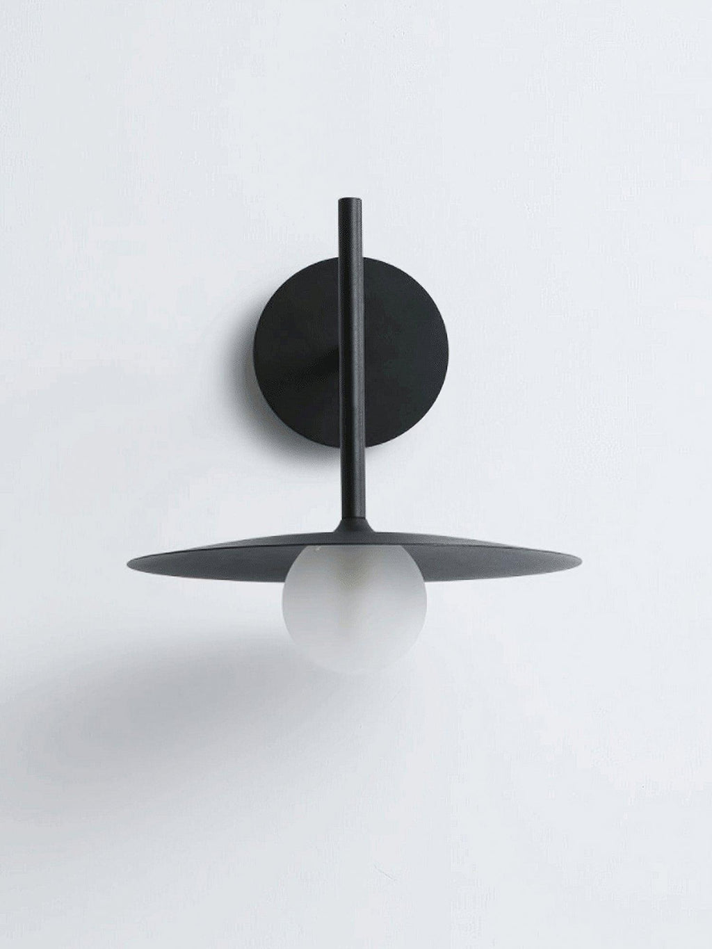 Studio view of this black Clérachic wall light, shown unlit against a plain white backdrop.